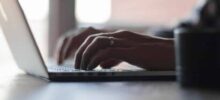 A typing businessman’s hand on a laptop working to register a business on sunbiz florida.