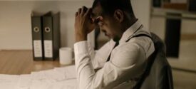 Stressed man at desk calculating tax on overtime