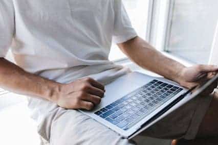Un hombre utiliza la aplicación «Where's My Refund» en una computadora portátil para seguir el estado de su devolución de impuestos