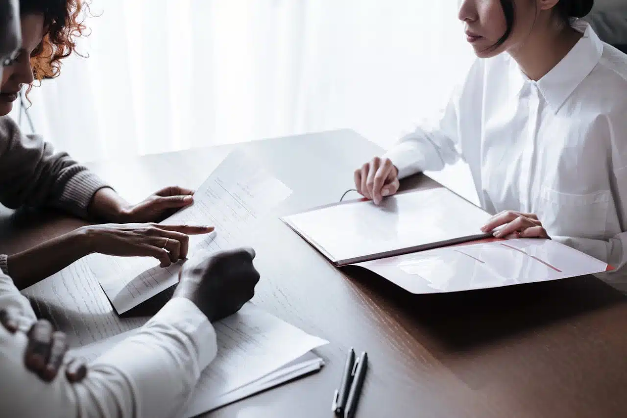 Business professionals reviewing documents during a consultation, possibly discussing the process to change LLC to S Corp status, emphasizing the importance of expert guidance in business structure transitions.