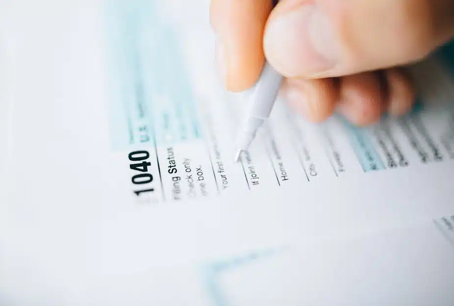 Person filling out IRS Form 1040, related to estimated tax payments for income reporting and tax filing