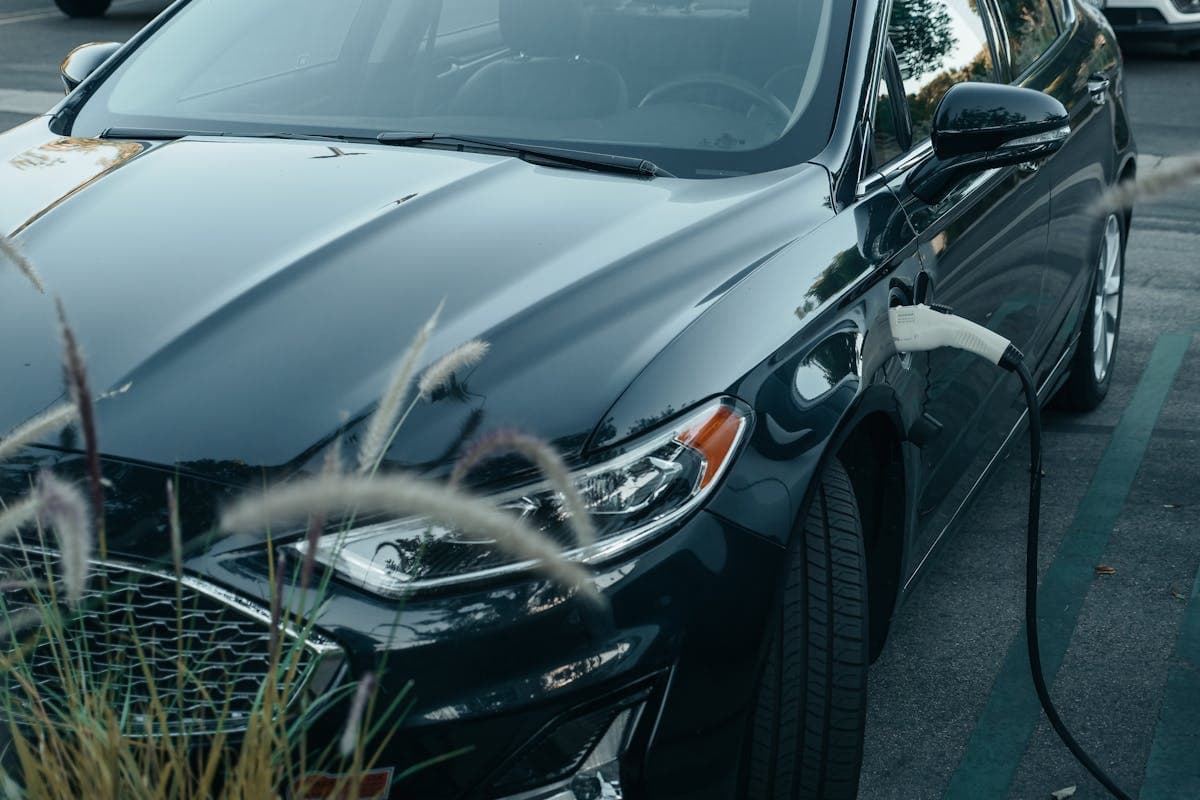 Electric vehicle charging with charging cable connected, highlighting potential EV tax credit benefits for eco-friendly transportation.