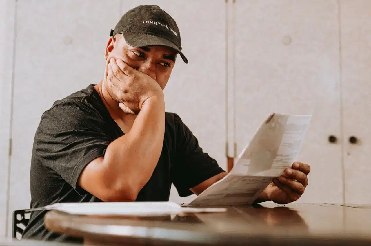 Person looking concerned while reviewing an official IRS CP2000 notice document, conveying the stress and uncertainty that can come with receiving such a tax-related communication.