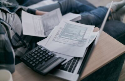 Tax documents and calculator on a desk, representing preparing an IRS Schedule E form