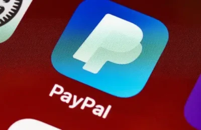 Close-up of PayPal app icon on a smartphone screen, displaying the blue and white logo, emphasizing the PayPal login process for mobile users.