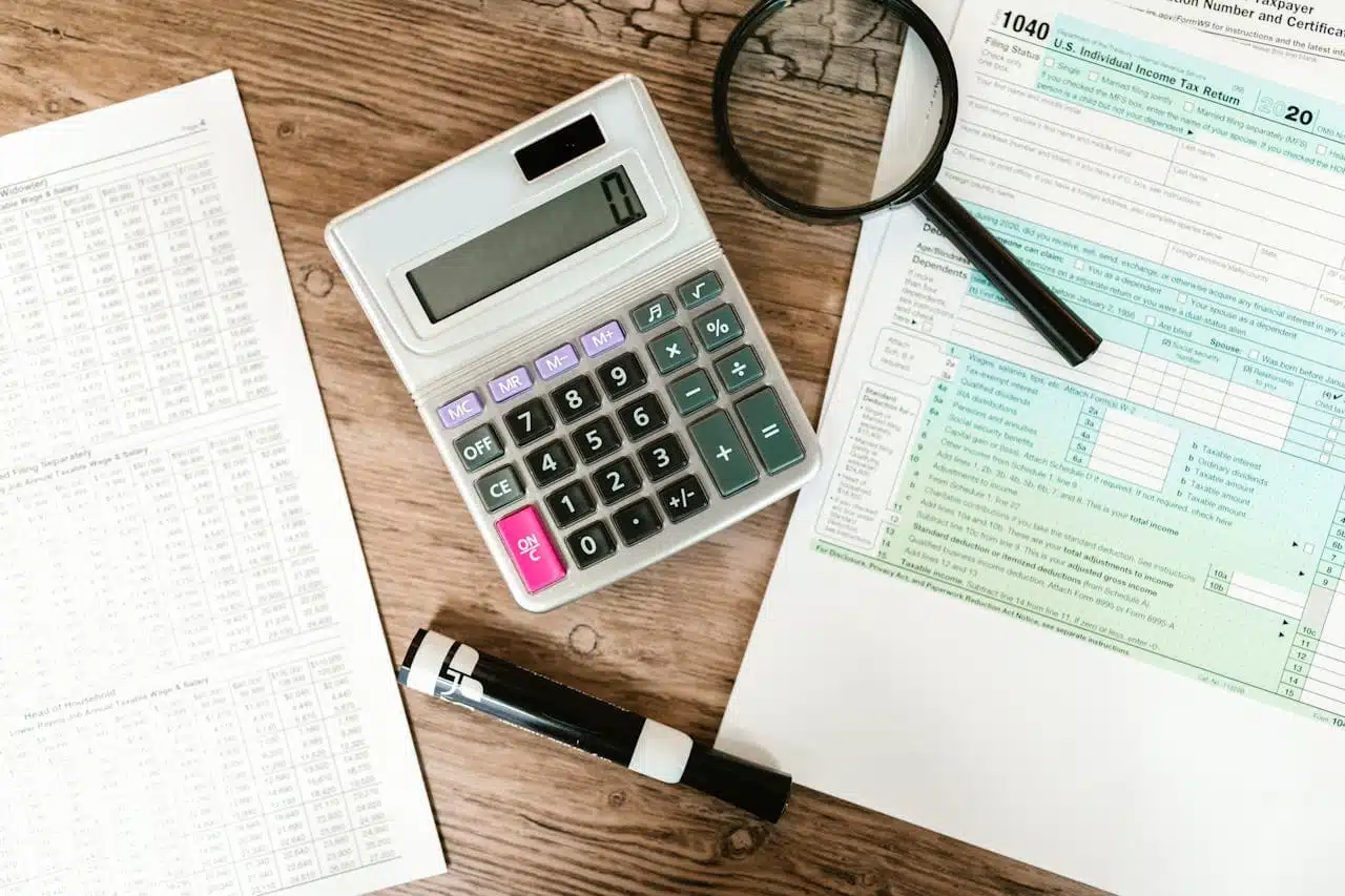 Tax Topic 151 preparation with IRS Form 1040, calculator, magnifying glass, and financial documents on wooden desk, illustrating the process of resolving IRS notices and calculating taxes.