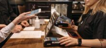 Venmo for teens payment at retail counter - customer demonstrating how a Venmo teen account works with digital payment terminal and smartphone