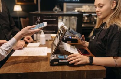 Venmo for teens payment at retail counter - customer demonstrating how a Venmo teen account works with digital payment terminal and smartphone